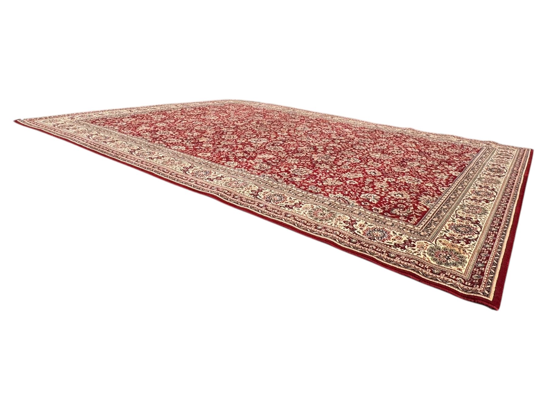 Royal Kashmir worsted wool modern Persian design area rug, with crimson field and stylised rosette patterning throughout, surrounded by wide multi-band border incorporating cartouche and lotus flower motifs