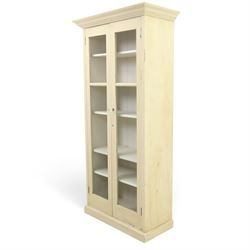 Traditional white painted pine display cabinet, projecting cornice above two glazed doors enclosing five fixed shelves, tongue and groove back raised on a plinth base