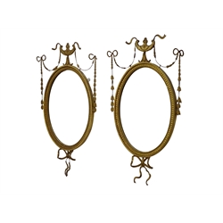  Pair of Edwardian Adam Revival carved gilt wood and gesso wall mirrors, oval bevelled plates with ribbon tied, urn and harebell cresting, H83cm, W49cm (2)  