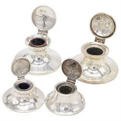 Four early 20th century silver mounted capstan inkwells, all of typical circular form with hinged covers, all hallmarked 