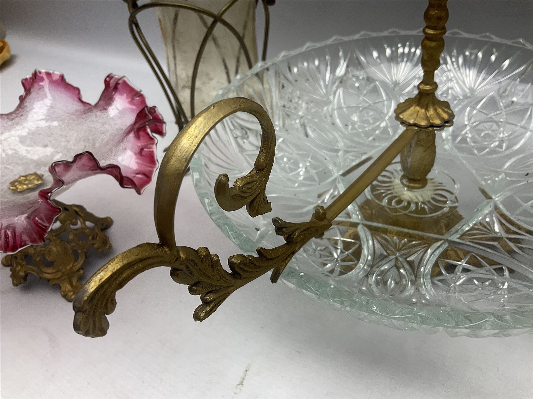 20th century moulded glass and gilt centre piece bowl with carrying handle and ornate trefoil base, together with frilled cranberry edge glass comport with ornate gilt base, and further centre piece with  large glass handle of twisted form, tallest H54cm