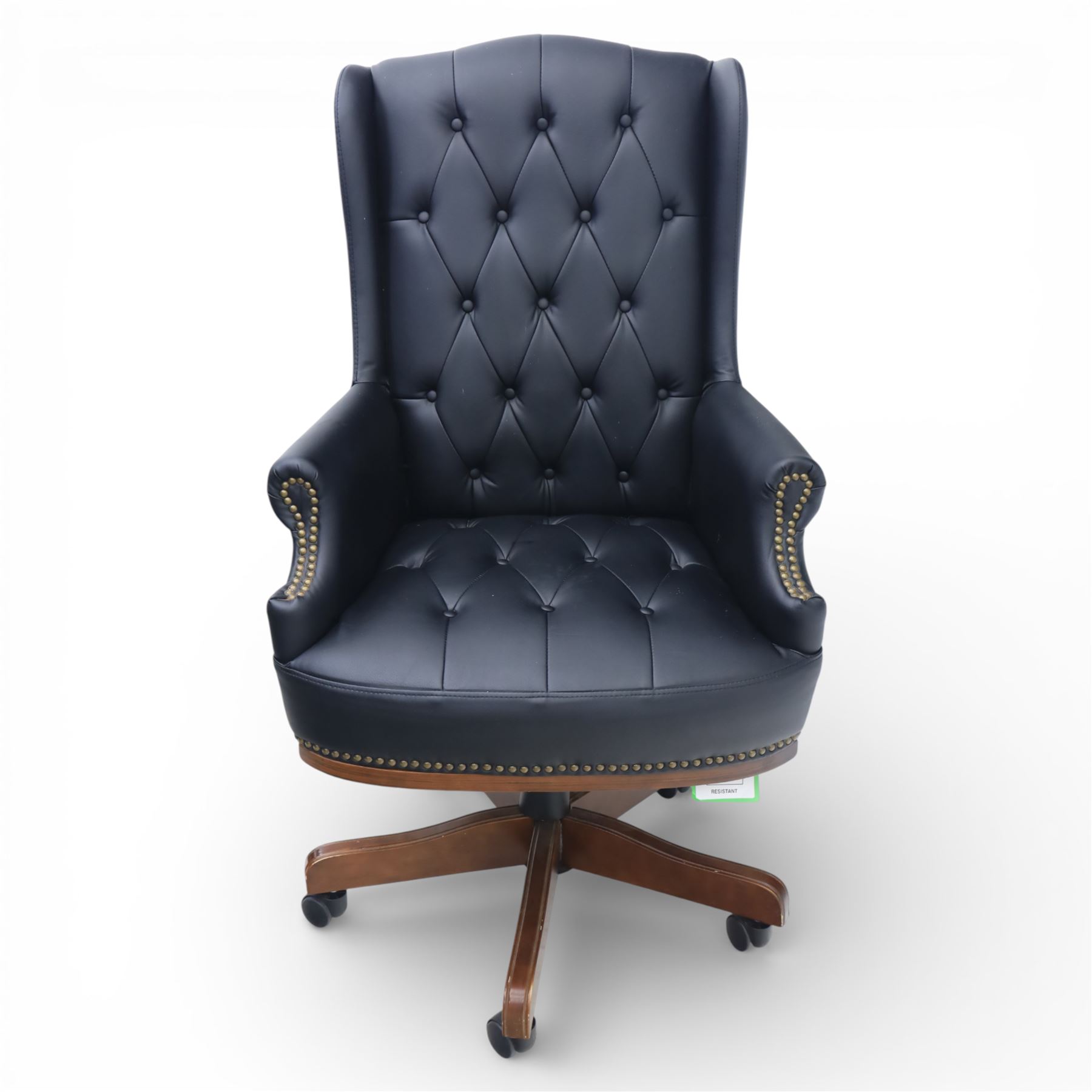 Chesterfield style desk chair upholstered in black, brass studded trim with tall button backed seat, with faux wooden base raised upon castors