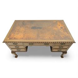 Waring & Gillow - Early 20th century mahogany desk, the leather-inset top above a shaped kneehole, central compartmented frieze drawer flanked by twin banks of of three drawers, each with brass handles, raised on cabriole legs with carved ball and claw feet (Height from floor to underside 62cm)