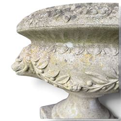 Regency design weathered cast stone garden urn of kylix form, the anthemion and arrowhead moulded everted rim over a fruiting laurel and lion-mask relief decorated body, waisted socle on square base, stamped HGC