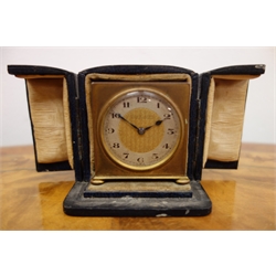  Art Deco small gilt brass cased travelling clock by Zenith, c1930, the silvered chapter ring with Arabic numerals, fixed key wind movement with alarm facility, in original triptych style carrying case, retailed by Fillans and Sons Huddersfield H5.5cm  