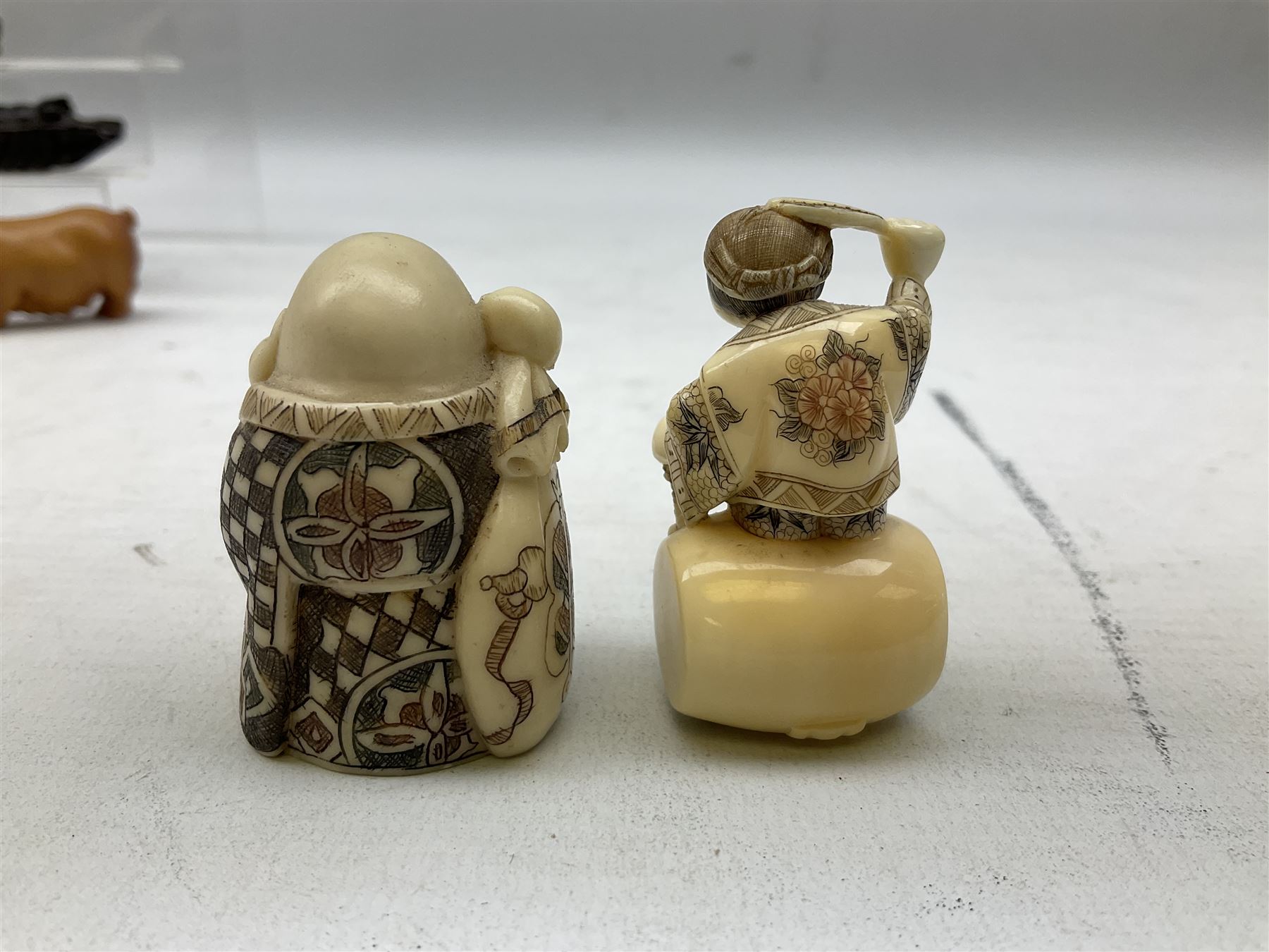 Group of ten Japanese netsukes, comprising eight carved wooden examples, and two ivorine examples, of various form, examples modelled as pigs, owl, mouse with tortoise upon its back, birds, rabbit, etc. 