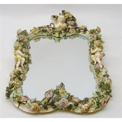  19th century Meissen style mirror, the rocaille frame heavily applied with roses amongst foliage, two winged cherubs below a maiden, H59cm x W37cm   