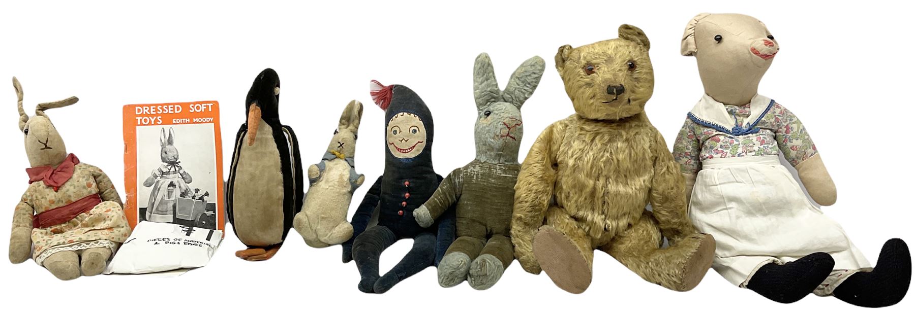 1950's teddy bear with jointed limbs, revolving head, wood filled body, stitched nose and mouth, applied glass eyes and foot pads, together with a quantity of handmade soft toy rabbits and penguins. 