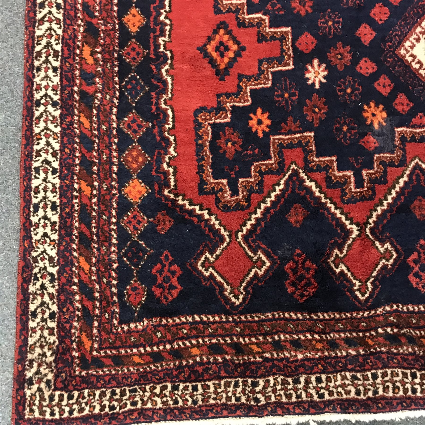 Persian style red and blue ground rug, three central diamonds