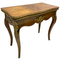 20th century French walnut and Kingwood card table, shaped fold-over top with figured quarter-matched veneers and floral egg and dart moulded edge in gilt metal, shaped aprons decorated with shell motifs with extending foliage, pull-out action base revealing storage well, on cabriole supports with ornate gilt metal mounts 