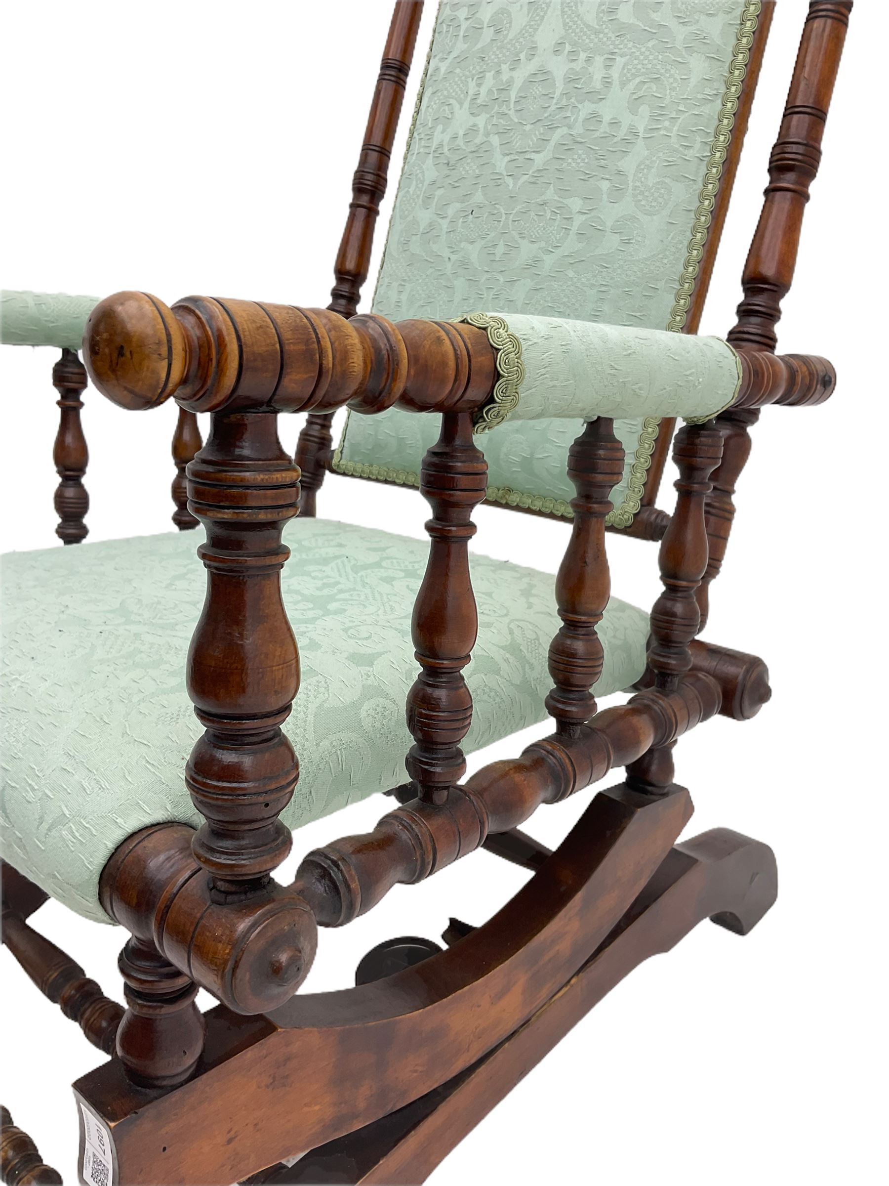 Early 20th century walnut framed American rocking chair, upholstered seat, back and arms