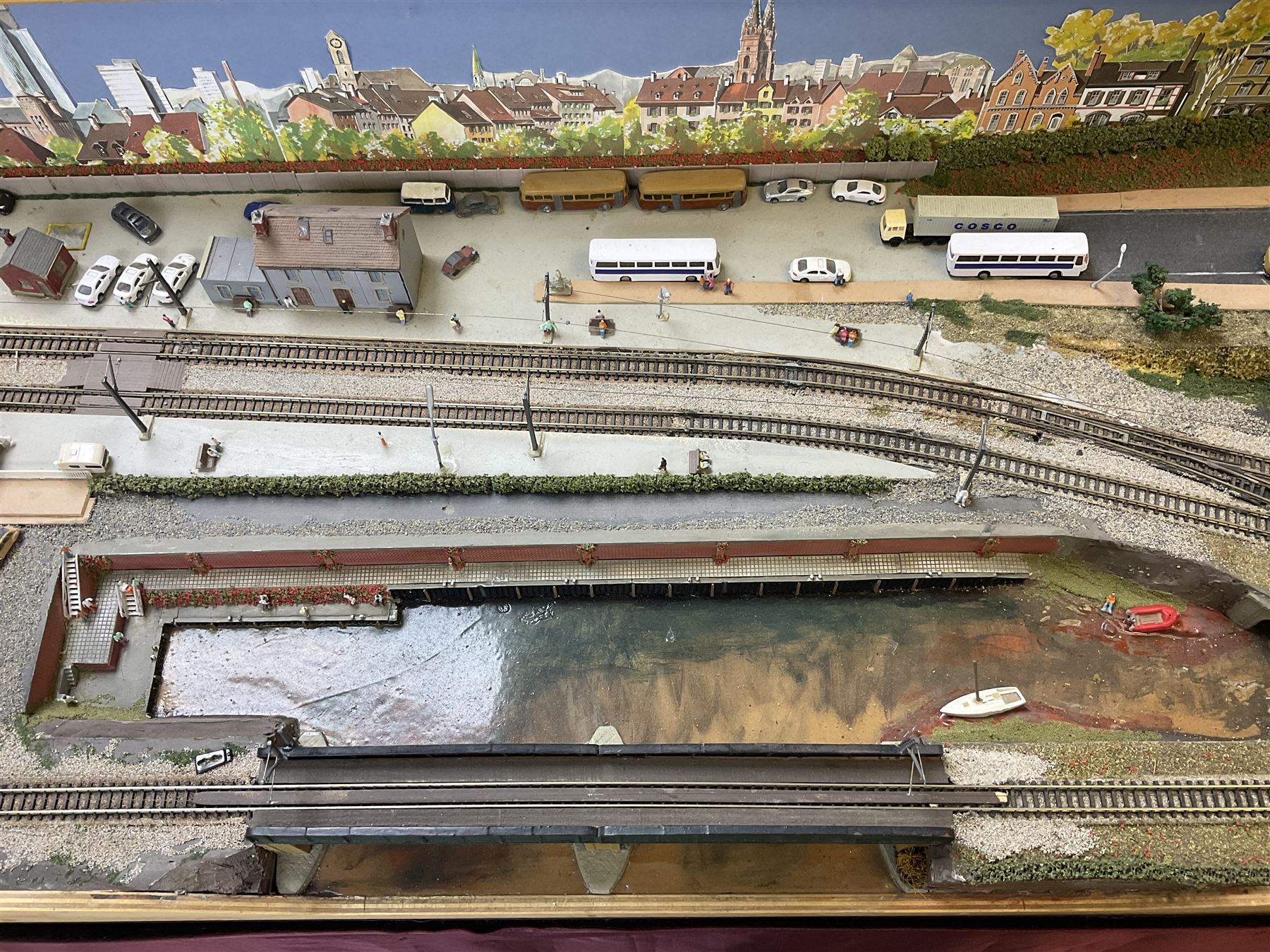 'Z' gauge continental scenic layout with folding legs, various loops of track and sidings with overhead cables, buildings including water tower, tunnels, roads with motor vehicles and figures, trees, haven with boats, backdrop diving wall hiding control units 150 x 50cm