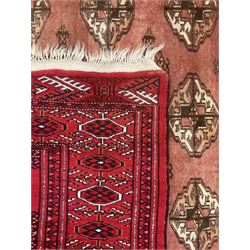 Afghan Bokhara red ground rug, the field decorated with five rows of Gul motifs, guarded border decorated with lozenges and geometric pattern 