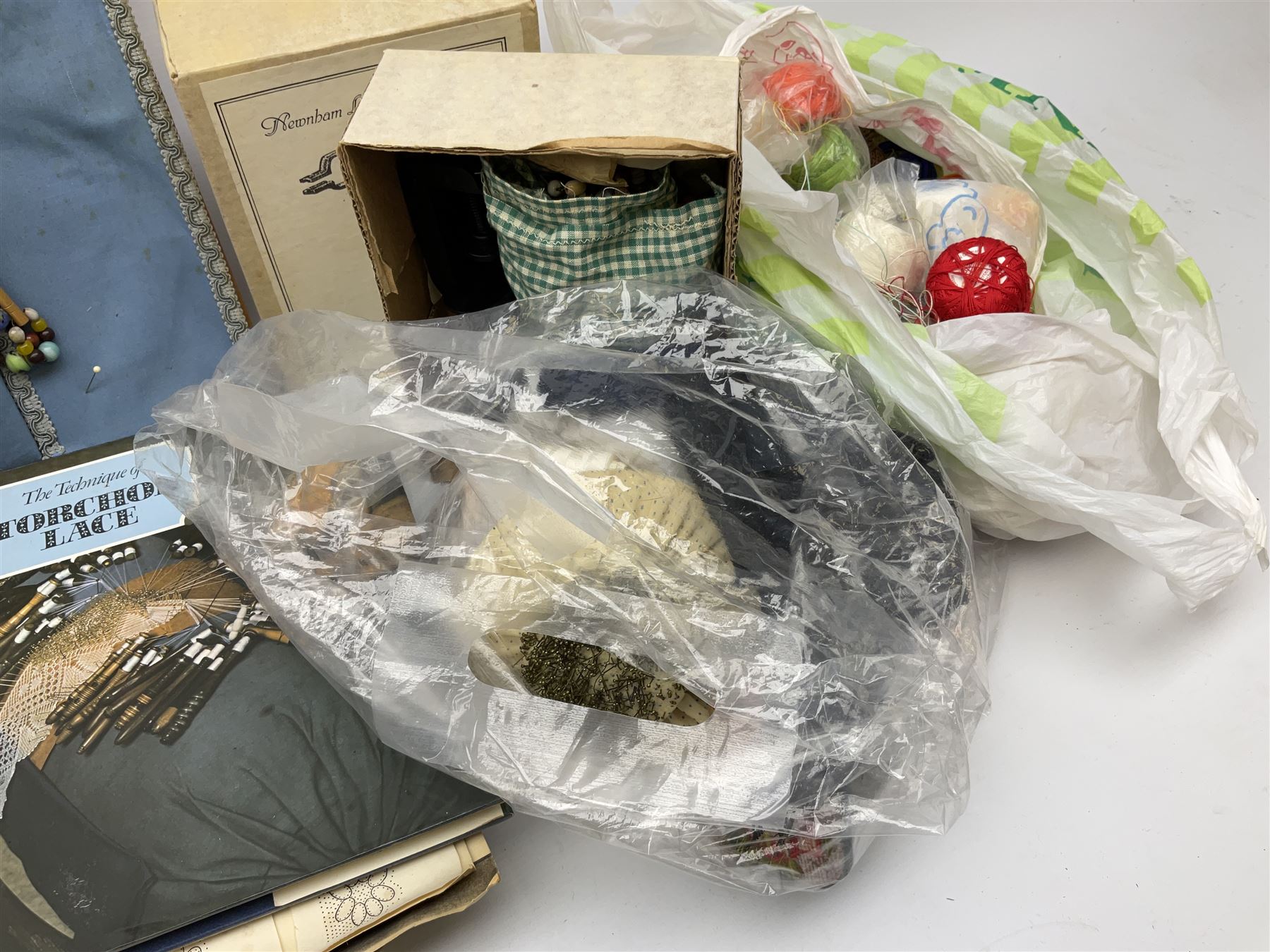 A quantity of lace making equipment, to include pillows, wooden bobbins, boxed bobbin winder, books, etc. 
