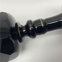 19th Century Bohemian amethyst glass lidded goblet, the bowl of faceted form, gilded with three children in period dress playing games, upon a knopped stem and conforming faceted foot, together with an art nouveau green glass goblet, with gilded rim, upon clear trumpet stem, and a hand blown wine glass, transfer printed with birds and three figures in period dress, tallest H29cm