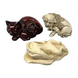 Japanese Meiji ivory Netsuke, modelled as a frog upon a lily pad, together with a further example modelled as a Dog of Fo, and a simulated amber netsuke modelled as a cat and kitten, (3)   