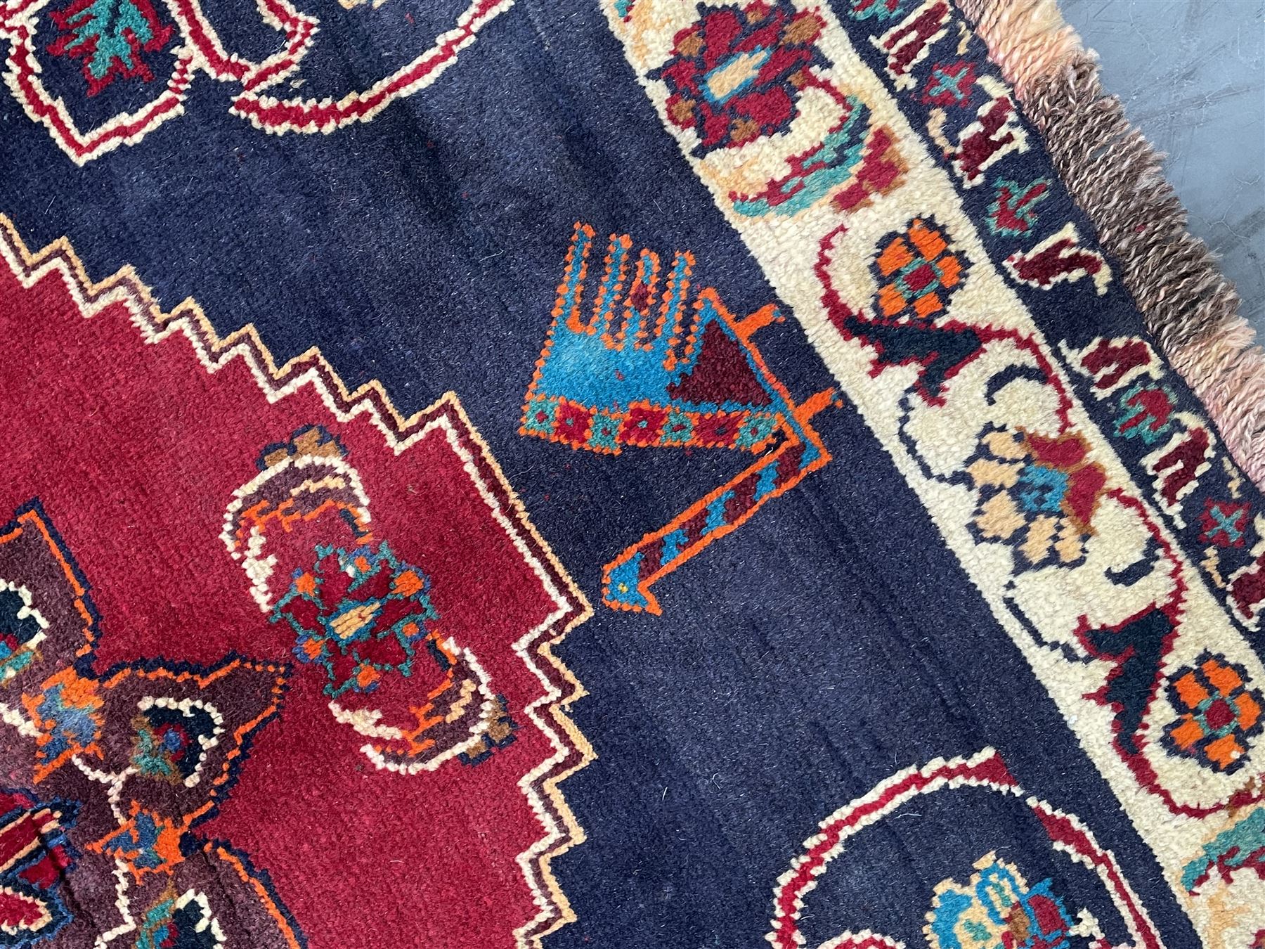 Persian rug, red ground field decorated with stylised flower heads and bird motifs, floral scrolling border