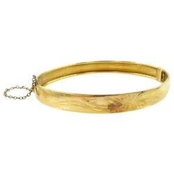 18ct gold hinged bangle, with engraved foliate decoration, stamped 750