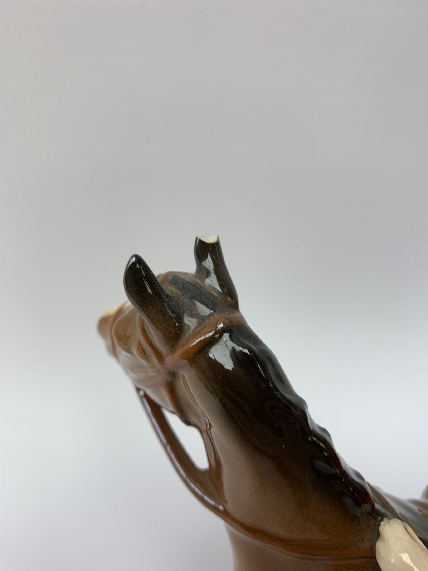 A Beswick equestrian figure modelled as a huntsman on bay horse, with printed mark beneath, together with a Beswick Norman Thelwell figure of a pony and rider, with printed mark beneath  