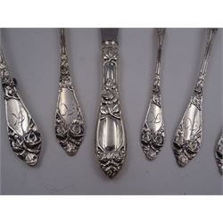 1930s Norwegian silver cutlery for six place settings, comprising table spoons, table forks and silver handled table knives, cake forks, tea spoons and demitasse spoons, one cake slice, serving spoon, sauce ladle and a pair of silver handled servers, all embossed with rose decoration and engraved with initial K to terminal and 10/9 1932 verso, stamped NM 830s