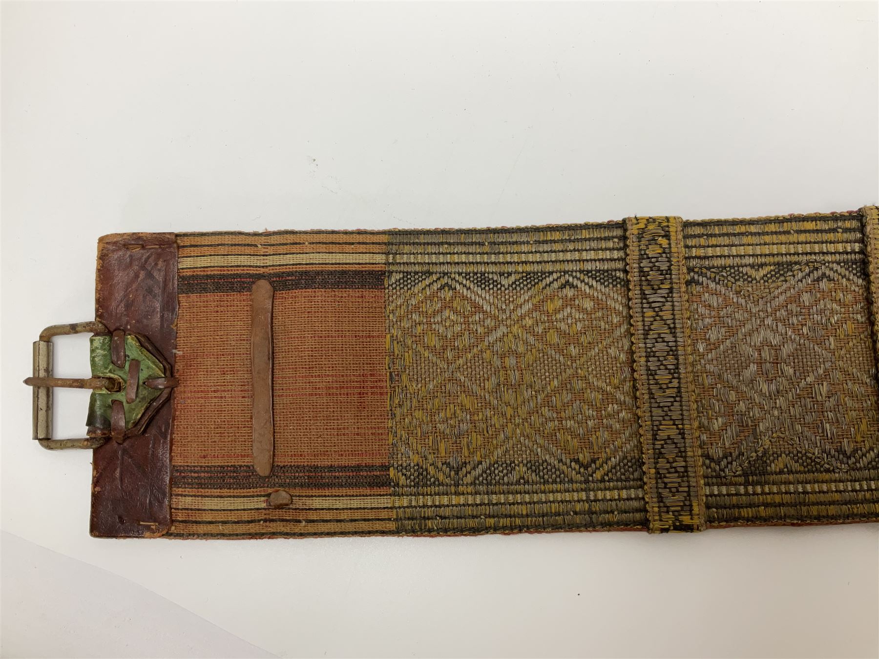 Late 19th century Yemeni Tuza jambiya as worn by religious elite, the 20.5cm curving blade with raised medial ridge, the horn hilt with pique style studwork, in a leather wrapped wooden scabbard with pierced metal mount and leather belt applied with embroidered 'gold' and 'silver' thread work panel; dagger L36cm overall, belt L84cm