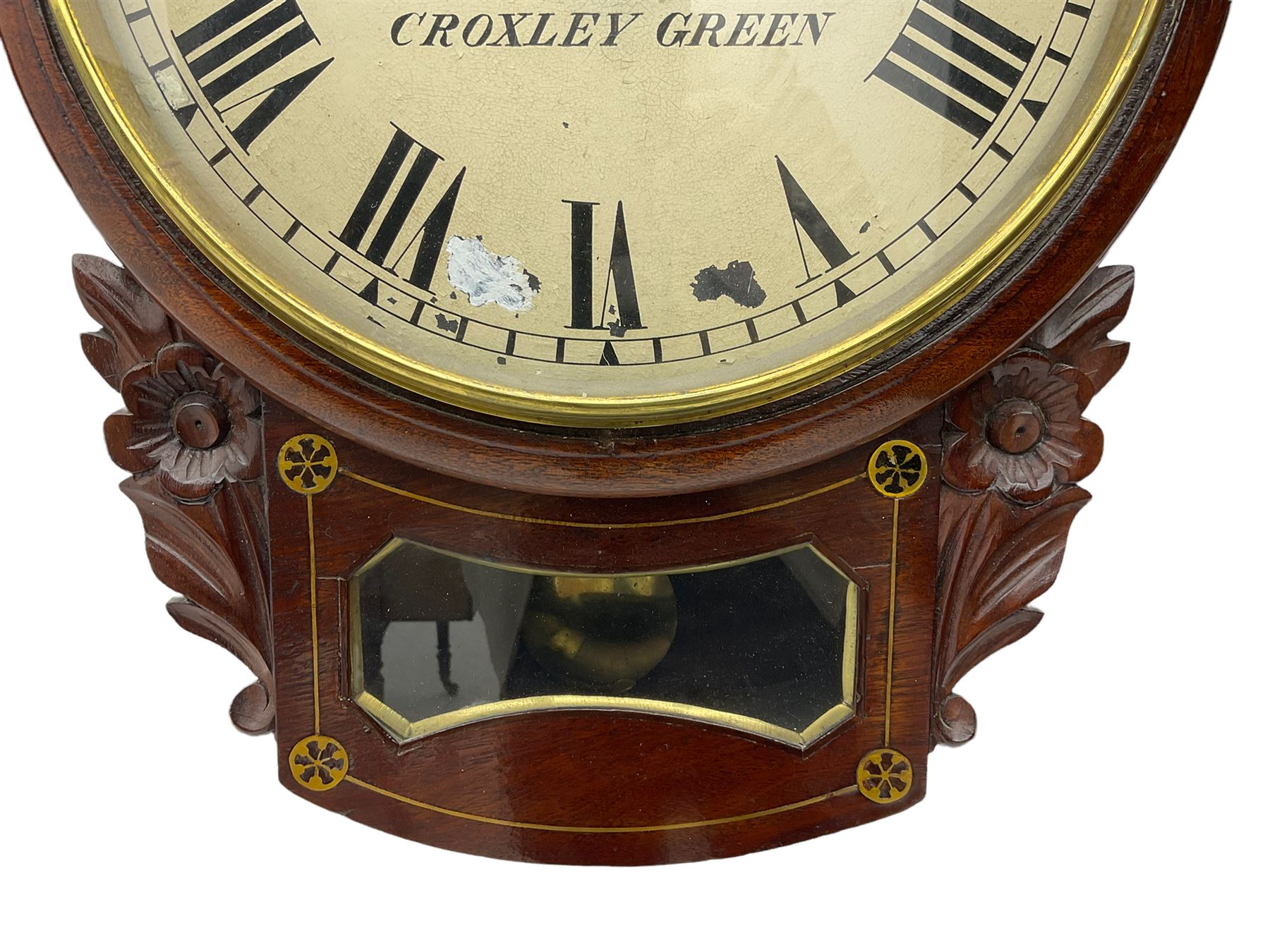 A late 19th century drop dial fusee wall clock in a mahogany case with brass inlay and a carved representation of flowers flanking the glazed pendulum viewing glass, with case side door and pendulum adjustment door, 12