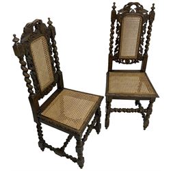 Pair of Victorian Gothic Revival carved oak chairs, decorated with pierced and carved vines with spiral turned uprights, cane seat and back, raised on barley-twist supports
