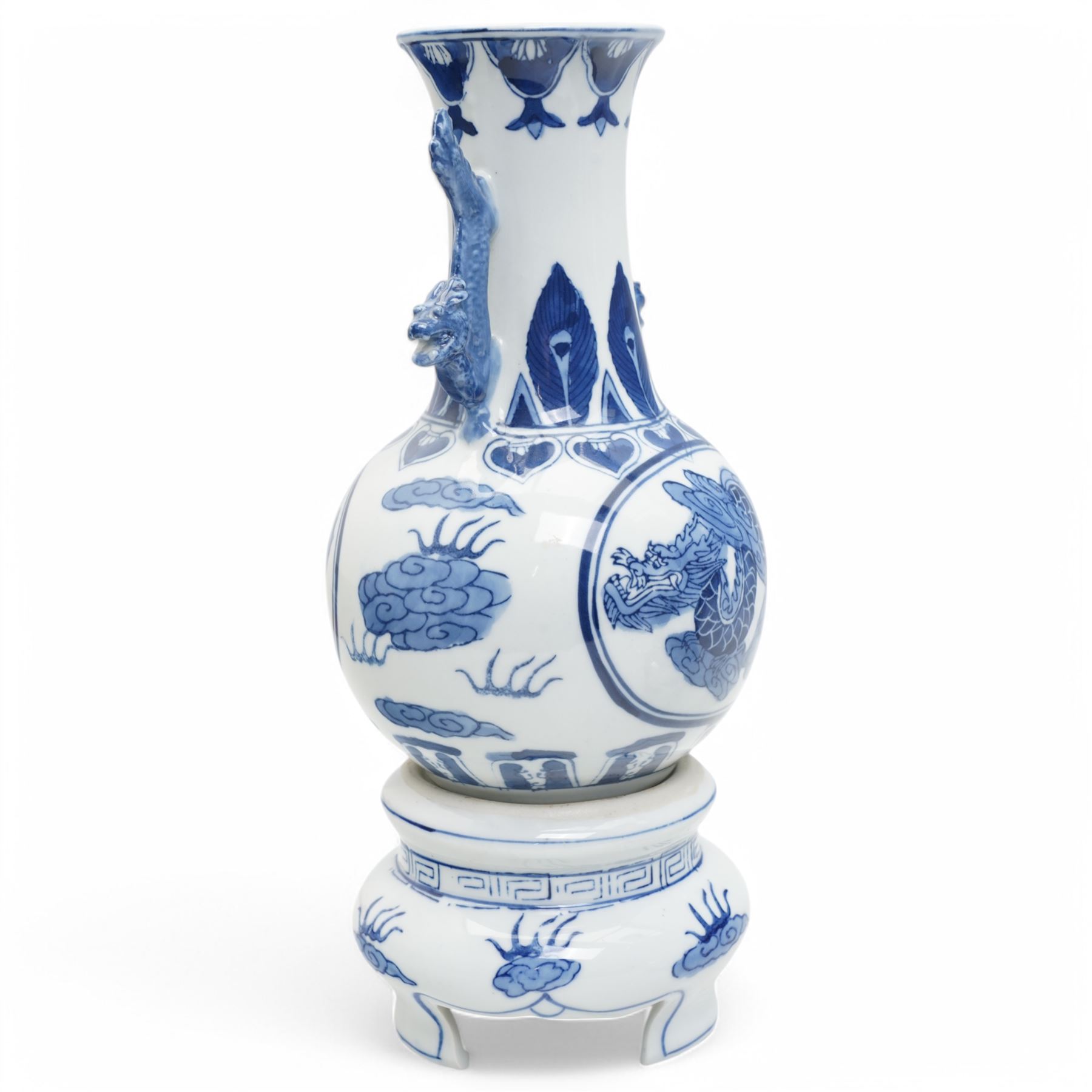Pair of Chinese blue and white vases and stands, of baluster form with elongated neck, decorated with painted scenes of dragons amongst clouds, the twin handles formed as two crouching dragons, including stands H32cm