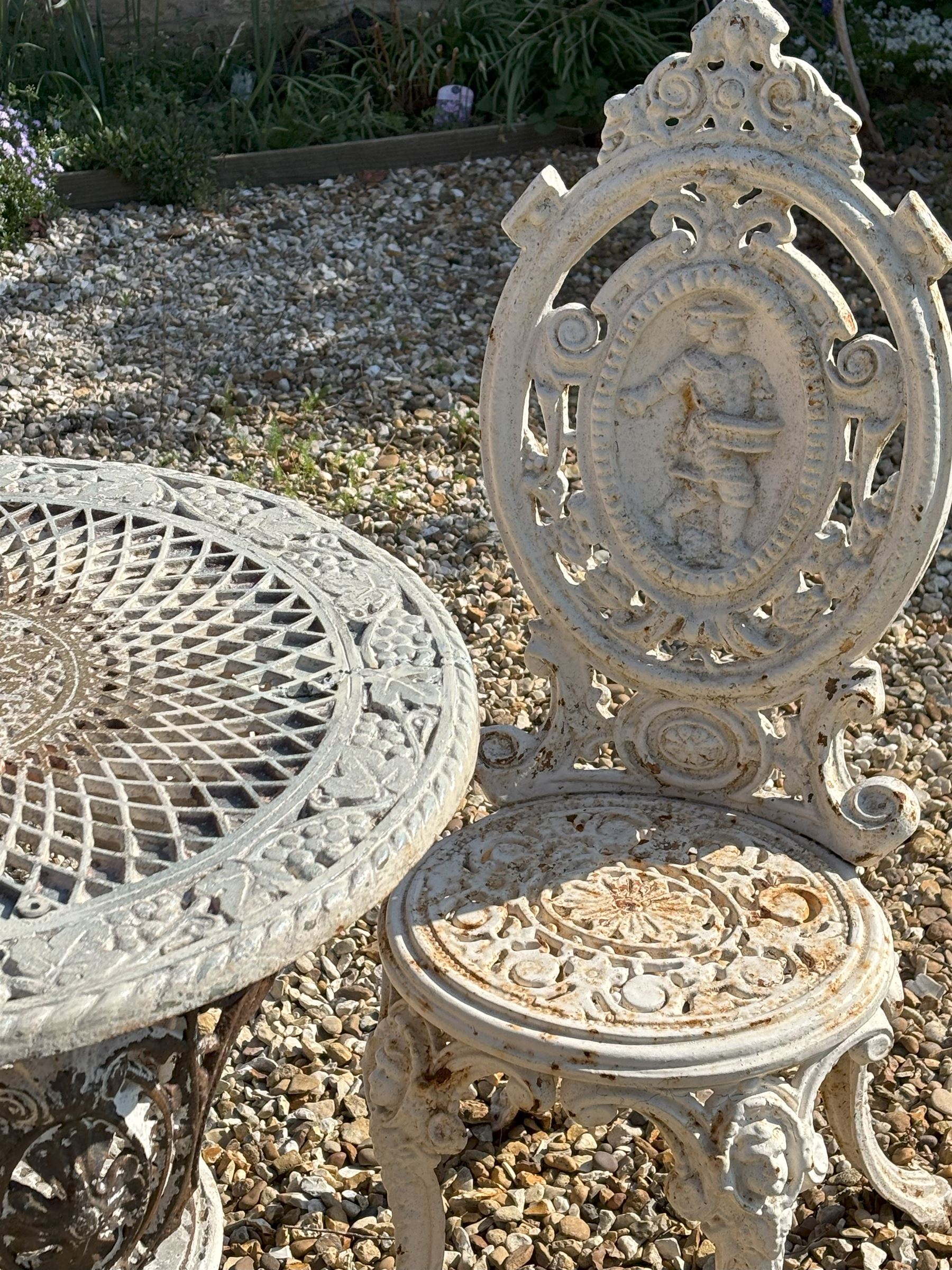 Victorian white painted cast iron garden chair, the figural cartouche back above an openwork seat, raised on cabriole supports (H96cm) together with a  cast iron garden table (H74cm, D62cm)  - COLLECTION BY APPOINTMENT FROM: The White House, Thirsk Road, Easingwold, York, YO61 3NF - CALL 01723 507111 TO ARRANGE
