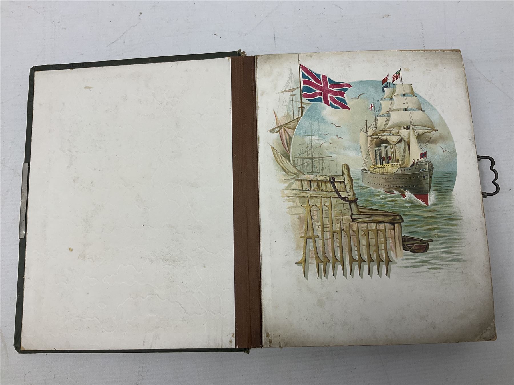 Victorian desk ink blotter, decorated with painted spray of flowers within stylised gilt rococo spandrels with mother of pearl fixings, together with a Victorian photo album containing interior leaves with apertures of various sizes and shapes of portraits surrounded by printed sea and dock scenes, blotter L28cm