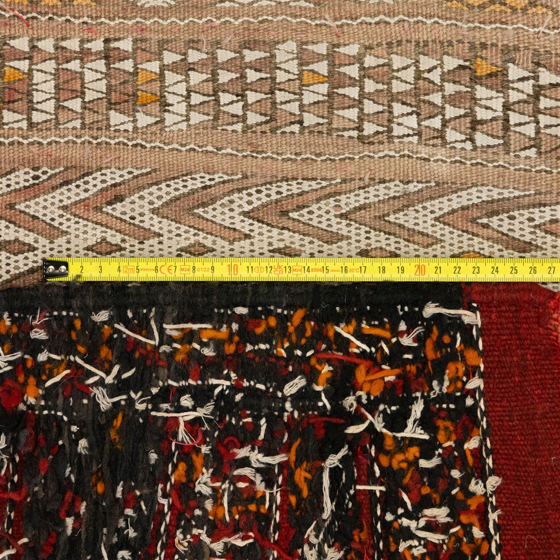 Berber style mid 20th century flat-weave kilim, woven is alternating horizontal bands of hooked lozenges, diamonds, and chevron motifs in a terracotta, ochre, ivory, and brown palette, framed by narrow geometric borders  