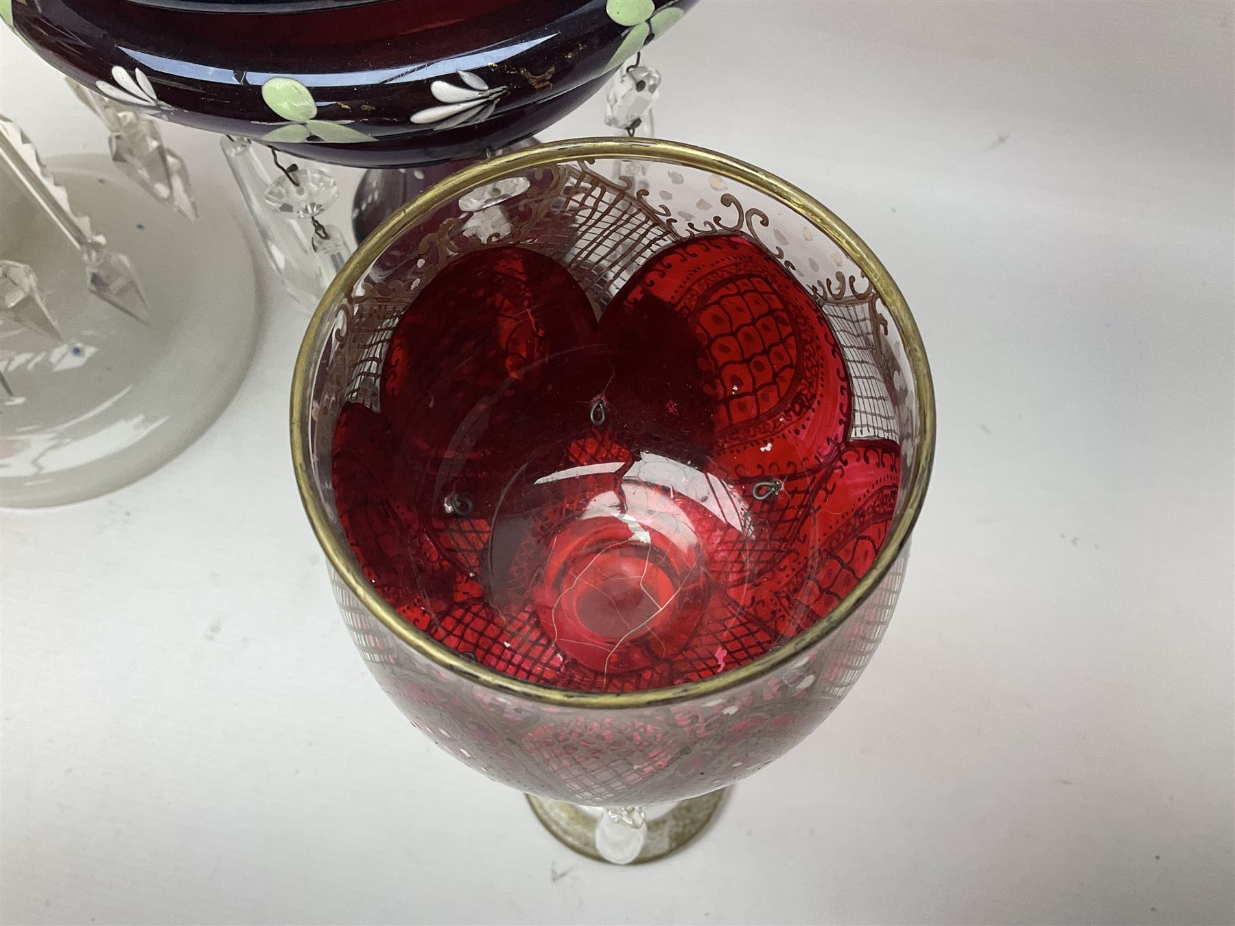 Bohemian red glass lustre, painted with stylised floral and foliate decoration, together with a milk glass example and two bohemian goblets converted to lustres 