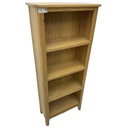 Contemporary light oak open bookcase, fitted with three shelves, on tapering supports