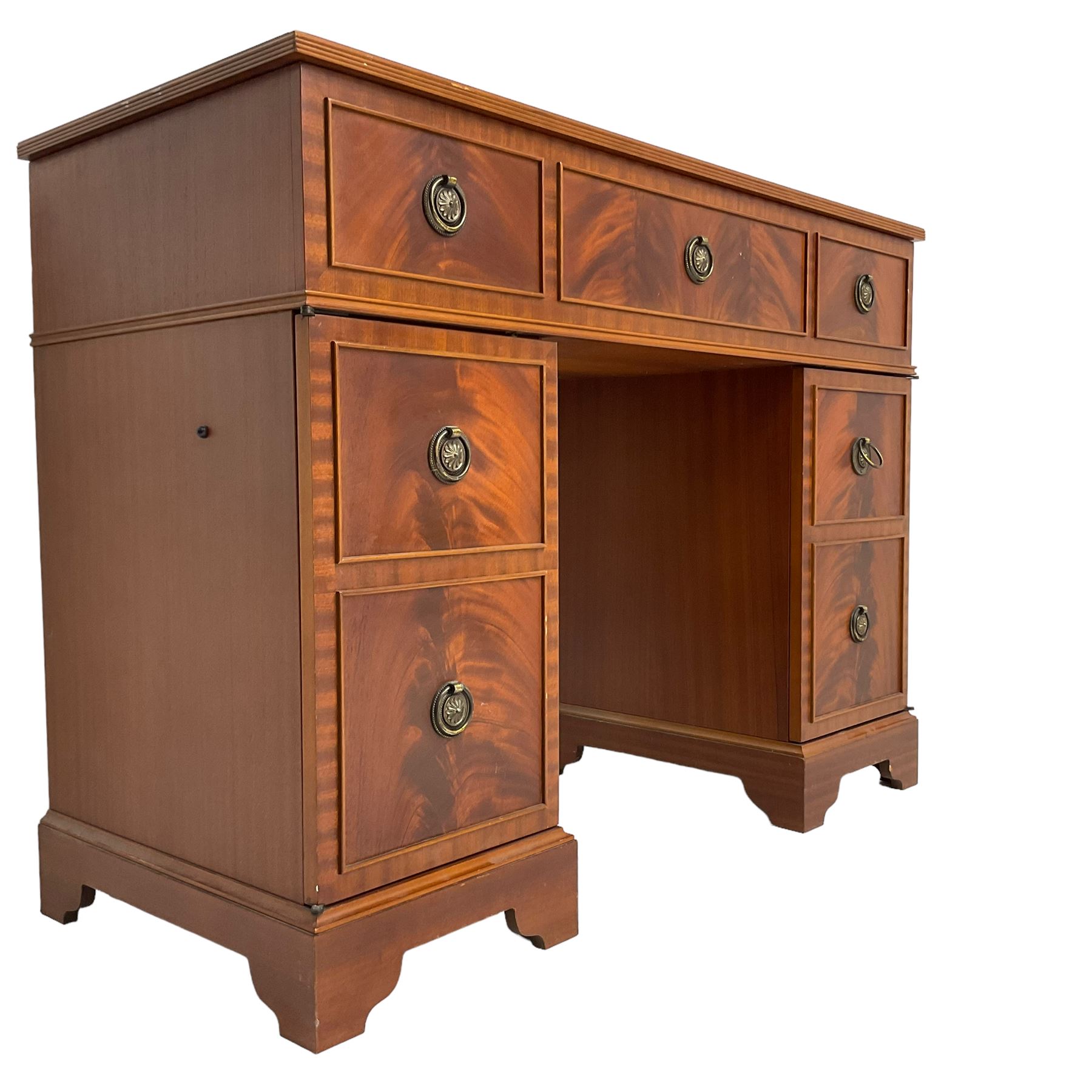 Music system in the form of a Georgian design twin pedestal desk, the reed moulded rectangular top hinges to reveal Garrard turntable with Dynatron Amplifier, fitted with speakers enclosed by two doors disguised as drawers, on bracket feet