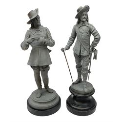 Matched pair of unpainted spelter figures of cavaliers - one standing removing his gloves, the other standing leaning on a walking cane; each on ebonised wooden base H47cm
