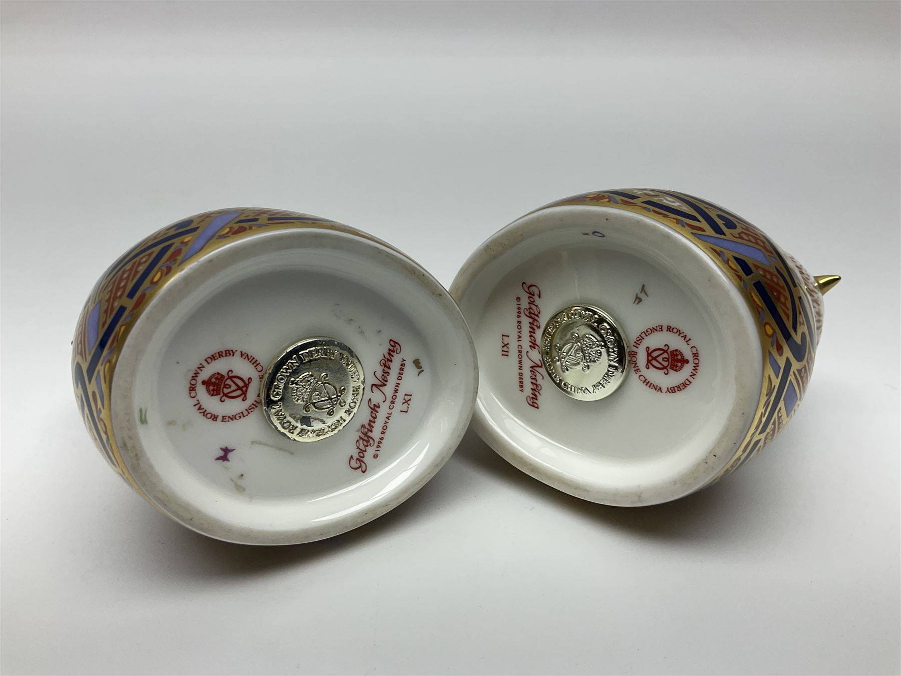 Two Royal Crown Derby Goldfinch Nesting paperweights with silver stoppers, together with two Royal Crown Derby imari pin dishes, largest dish D13cm