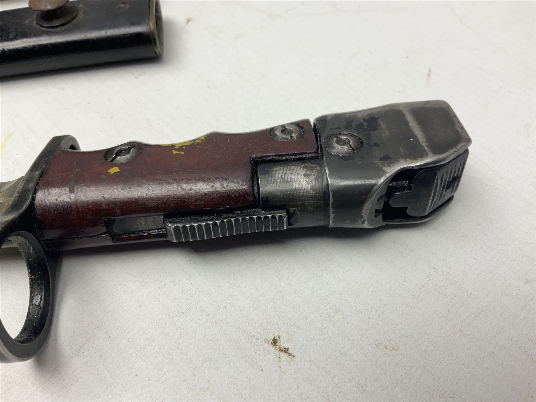 British No 7 MKI knife bayonet with 20cm single edged fullered clipped point blade;  blackened steel, large muzzle ring cross-guard; blackened swivelling pommel marked 'F5H'; red Tufnol composite grips; in blackened steel scabbard L33cm overall; British Pattern 1888 bayonet with scabbard; and German Ersatz bayonet with scabbard (3)