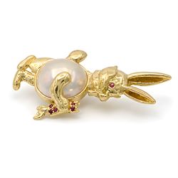 14ct gold ruby and mabe pearl bunny pendant / brooch, the bunny set with a single ruby eye and pearl, holding a ruby set carrot, stamped 585