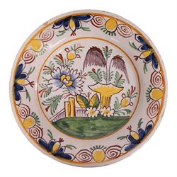 18th century Delft polychrome charger, decorated with a central landscape within a stylise...