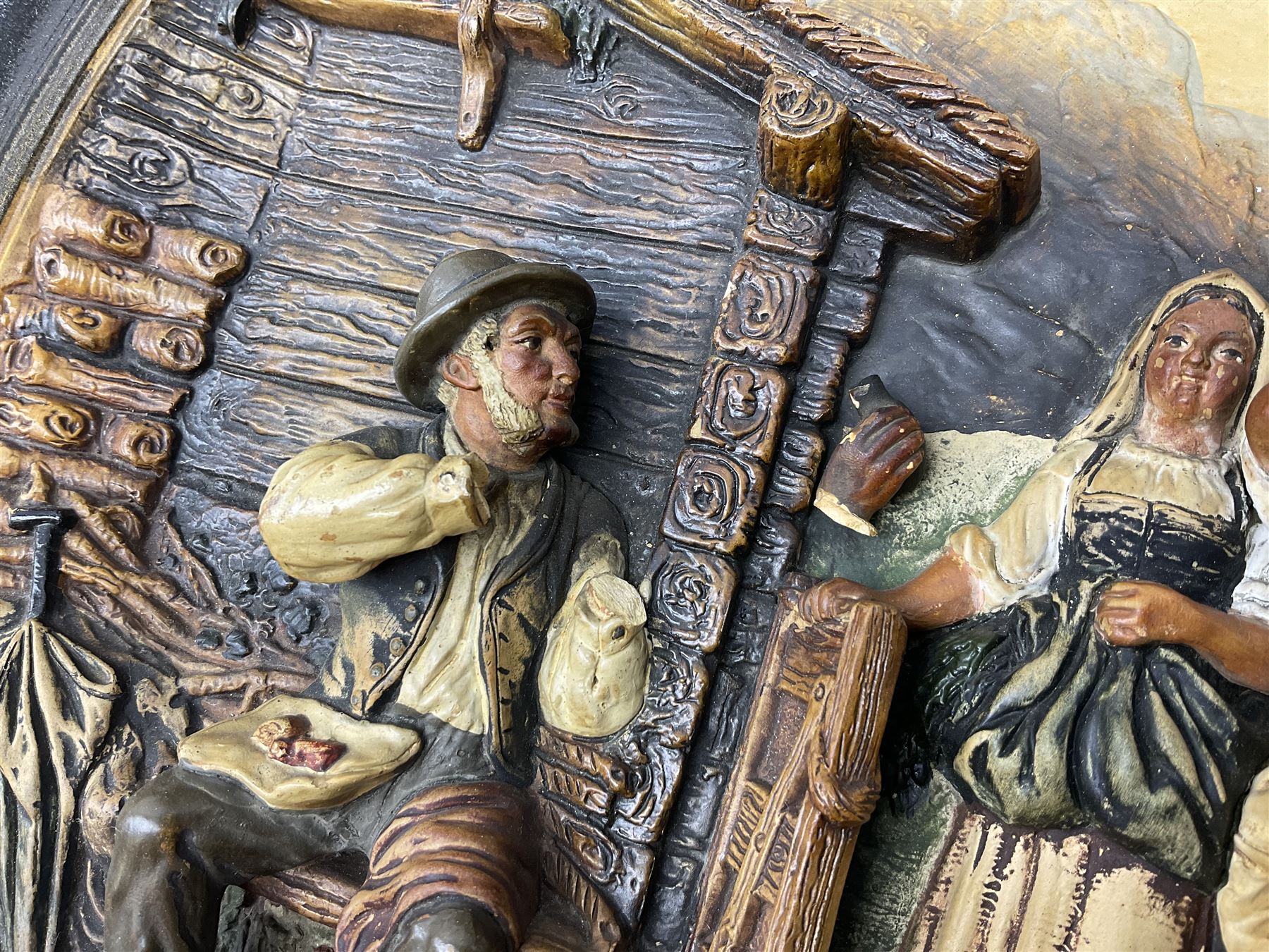 Two oil painted chargers decorated with joyful gentleman, both signed W Stanley, together with a Musterschutz charger decorated in high relief