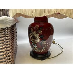 Table lamp of baluster form, decorated with blossoming flowers on a red ground, upon a wooden base, with a tasselled shade, together with a lined wicker basket with hinged lid, and a collection of reference books regarding  the royal family, lamp H60cm 