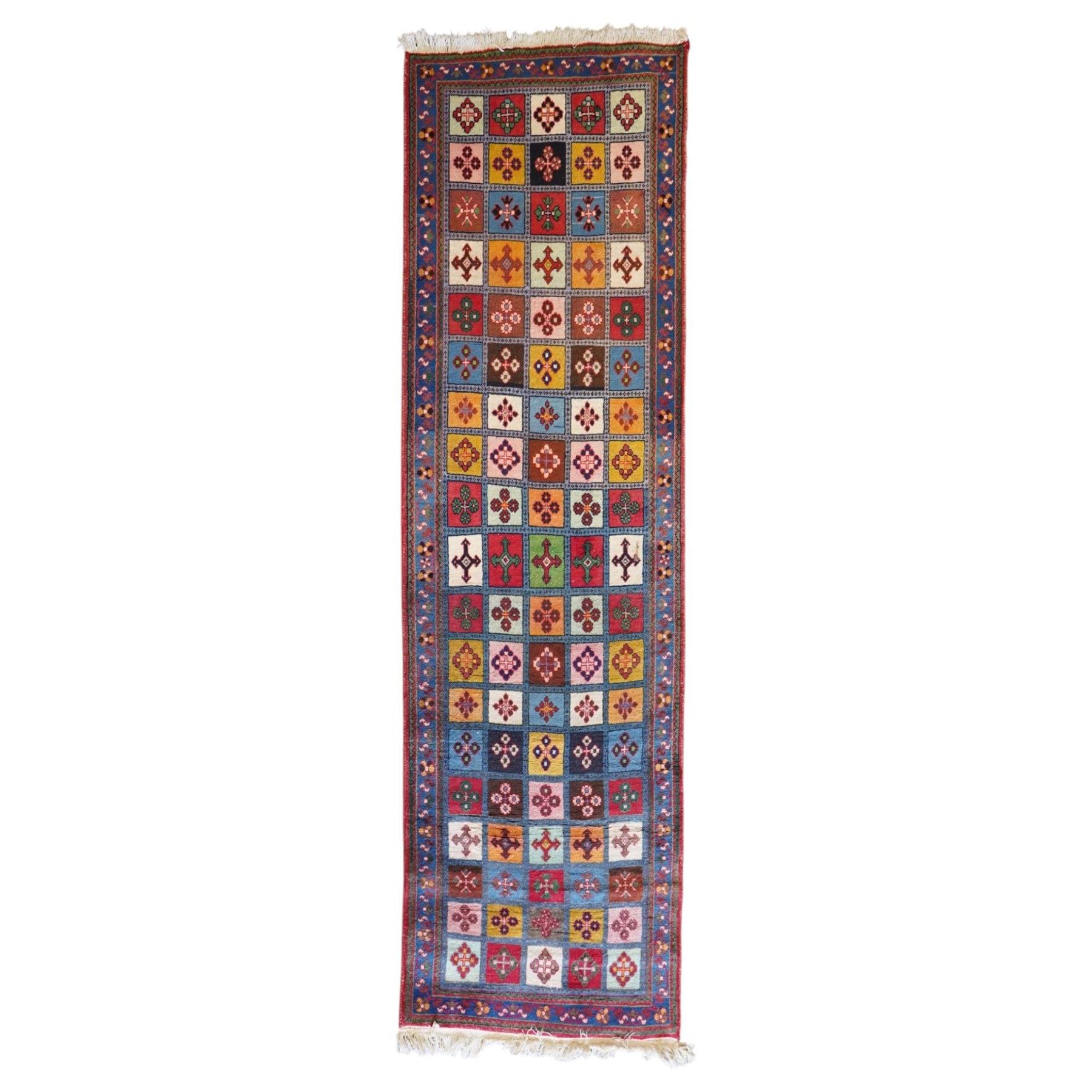 Persian Gabbeh indigo ground runner rug of garden design, the multi-coloured field decorated with five columns of panels in contrasting colours with stylised plant motifs, the guard band with trailing foliage