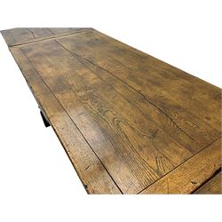 Early 20th century Jacobean design draw-leaf oak dining table, rectangular top with carved frieze depicting scrolling foliage and grape clusters, sliding extending leaves, raised on robust turned supports united by H-stretcher  