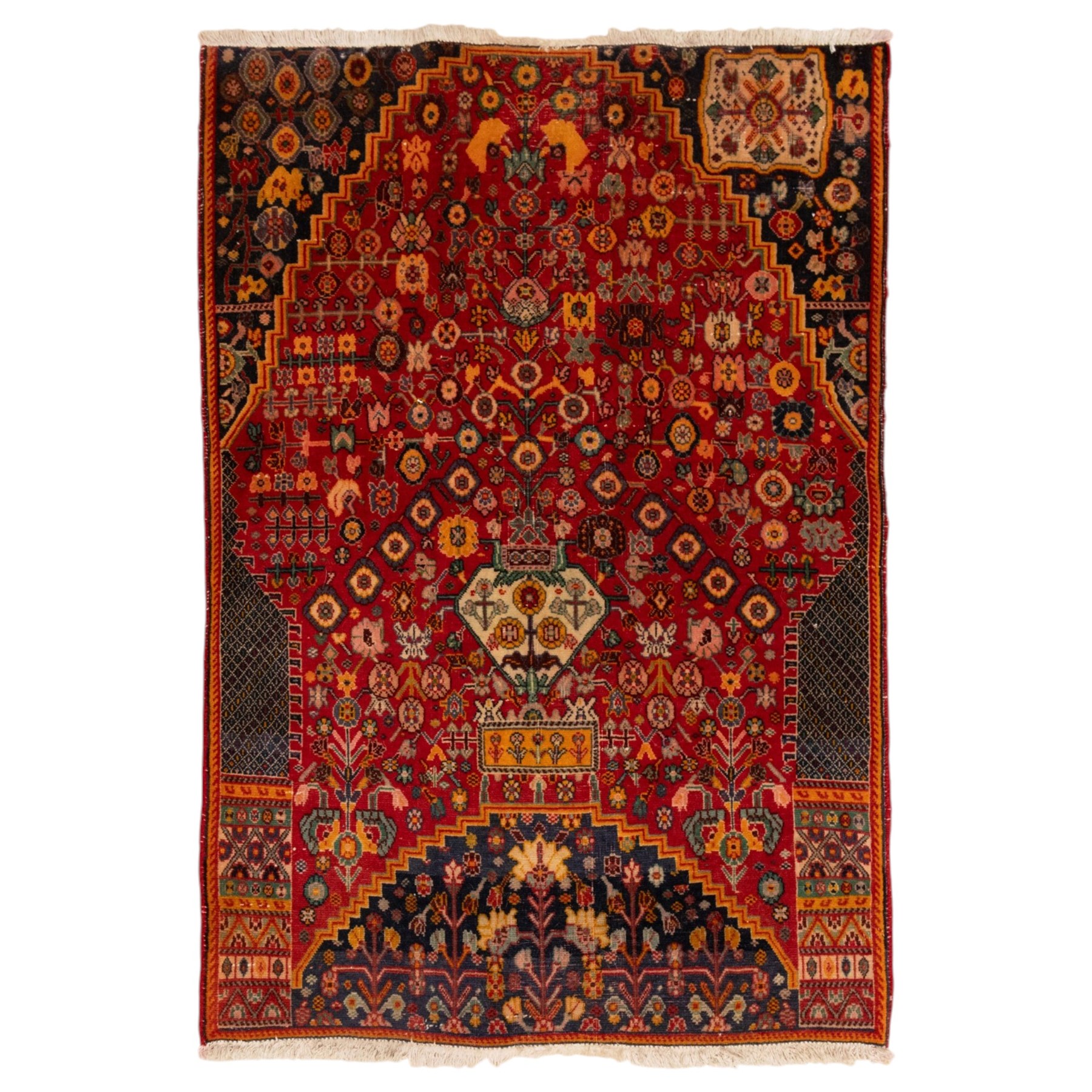 North Persian crimson ground rug, the field densely decorated with stylised flowering plants, urns and polychrome rosettes, within a stepped ochre outline, dark ground floral spandrels and geometric side panels