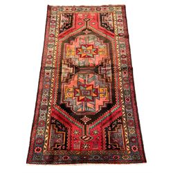 Persian Hamadan rug, red ground with two geometric medallions, decorated with animal and bird motifs, guarded border with the main band decorated with stylised flower heads