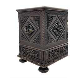 Early 20th century carved hardwood kist or mule chest of small proportions, moulded rectangular hinged lid over foliage carved geometric lozenge panels, the frame carved with chevron banding, fitted with two drawers, the drawer fronts carved with extending leaf motifs over a foliage carved lower moulding, on turned feet