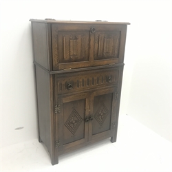 Mid 20th Century oak cocktail cabinet, carved drop front enclosing mirrored interior above single drawer and two cupboards, stile supports, W75cm, H122cm, D43cm