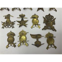 Over thirty British and Continental military metal badges; together with quantity of shoulder titles, collar dogs, rank pips, uniform buttons etc