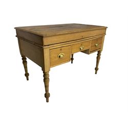 Early 20th century light oak kneehole desk, rectangular hinged top, fitted with frieze drawer flanked by two deep drawers, raised on ring turned supports