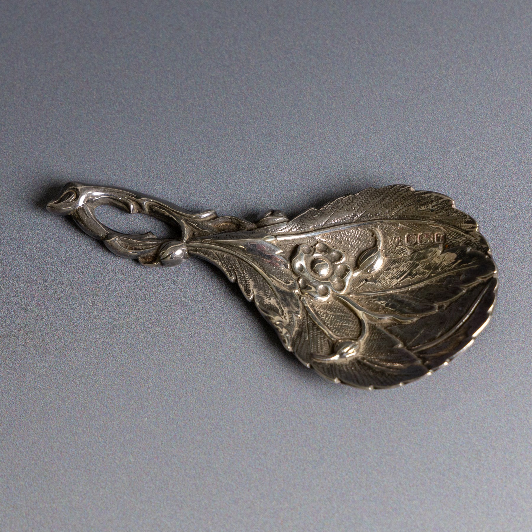 Late 20th century silver caddy spoon, naturalistically modelled with leaf shaped bowl, flowers and buds to centre, hallmarked Sheffield 1993, maker's mark indistinct